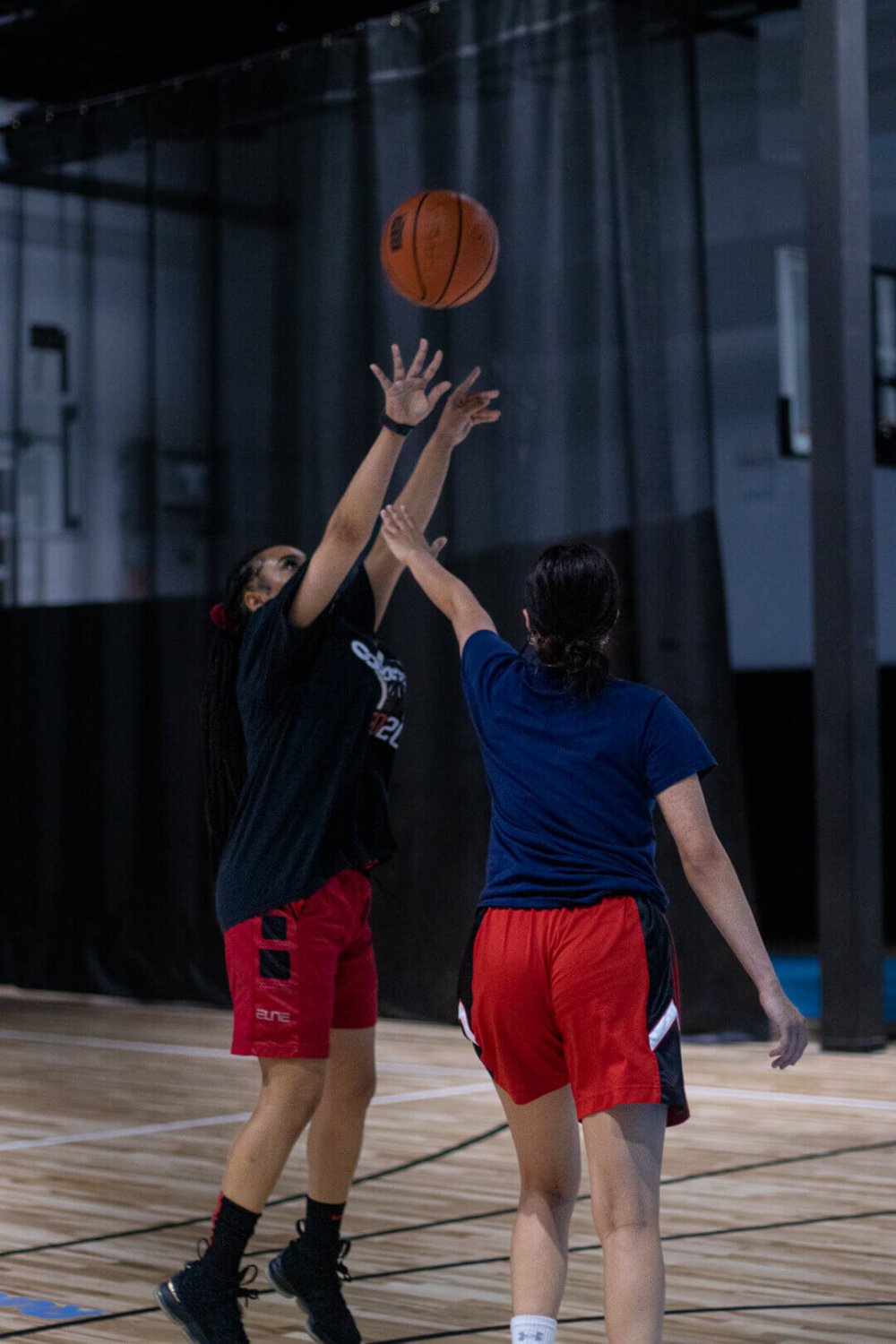 two girls play basketball